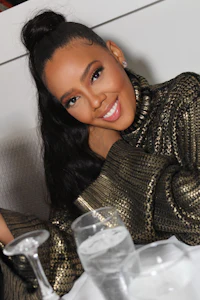 a woman sitting at a table with a glass of wine