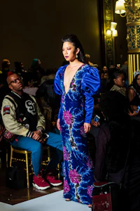 a woman in a blue dress walking down the runway
